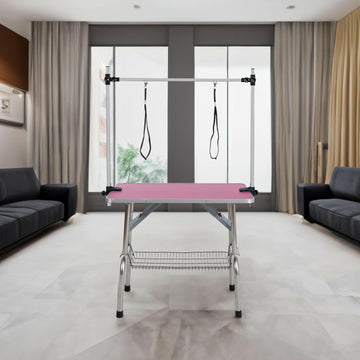Professional 36 inch folding pet grooming table with stainless steel frame and rubber pad, equipped with adjustable armrests and clips (pink).